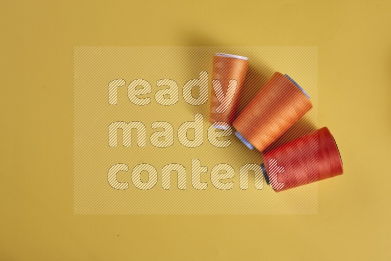 مجموعة من أدوات الخياطة والتفصيل برتقالية اللون على خلفية صفراء