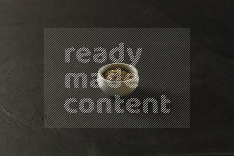 wooden round sauce bowl filled with herbs on grey textured countertop