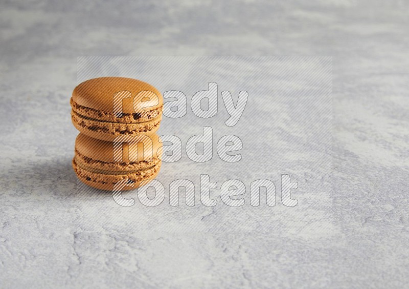 45º Shot of two Brown Maple Taffy macarons  on white  marble background