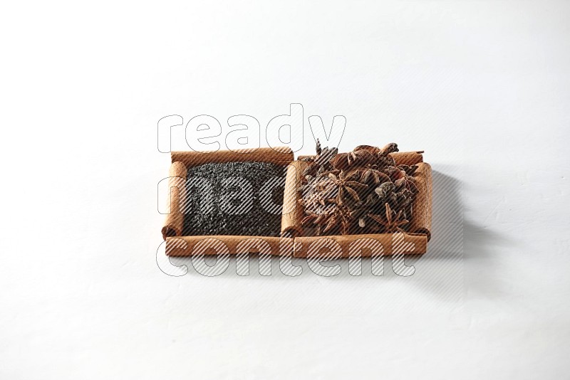 2 squares of cinnamon sticks full of black seeds and star anise on white flooring