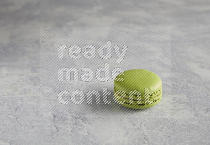 45º Shot of Yellow Lime macaron on white  marble background