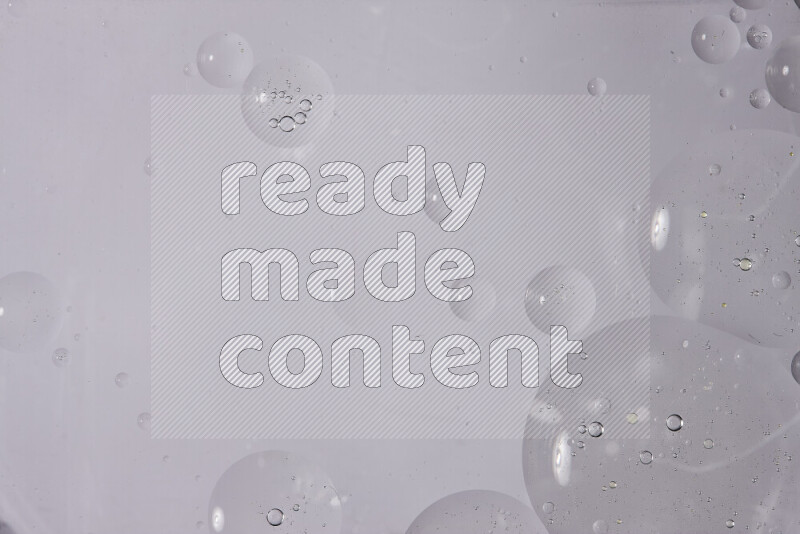 قطرات من الزيت على سطح الماء على خلفية بيضاء