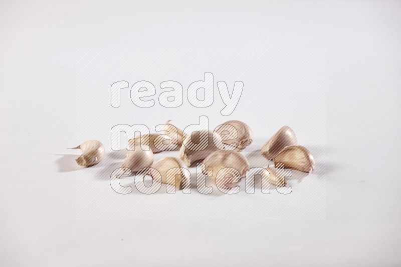 Garlic cloves on a white flooring in different angles