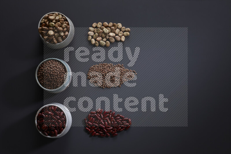 Legumes in pottery bowls on grey background