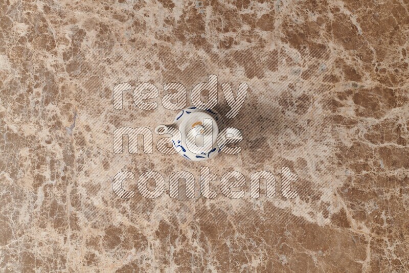 إبريق شاي فخاري على خلفية رخام بيج