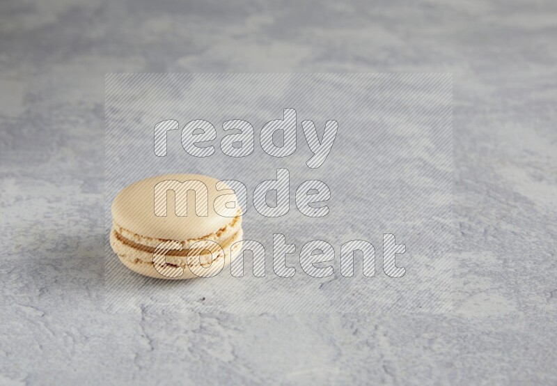 45º Shot of white marbleCaramel fleur de sel macaron on white  marble background