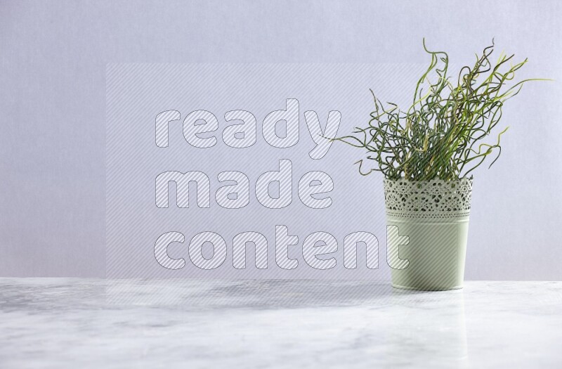 Artificial plant in green decorative pot on grey marble background