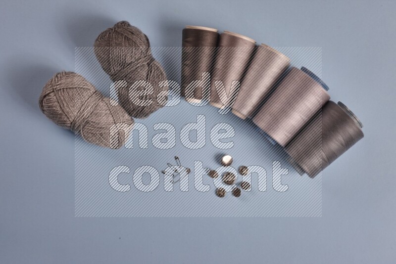 مجموعة من أدوات الخياطة والتفصيل رمادية اللون على خلفية زرقاء