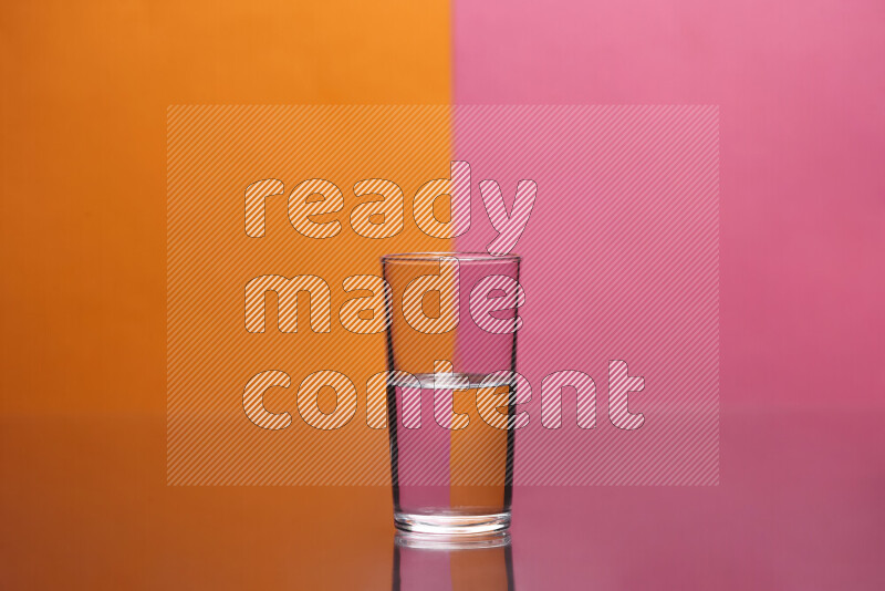 The image features a clear glassware filled with water, set against orange and pink background