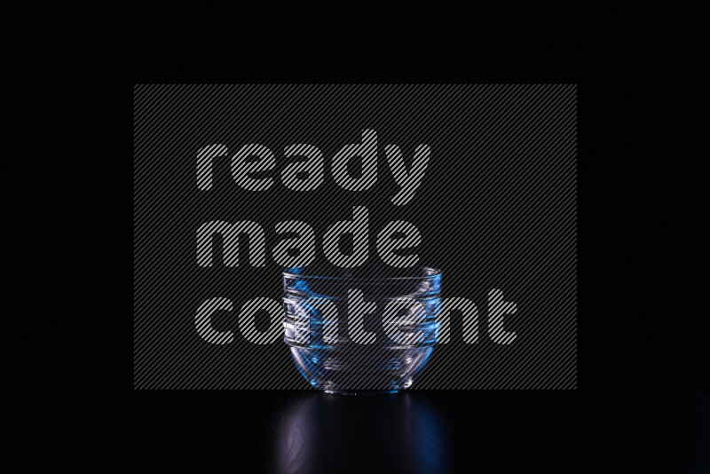 Glassware with rim light in blue and white against black background