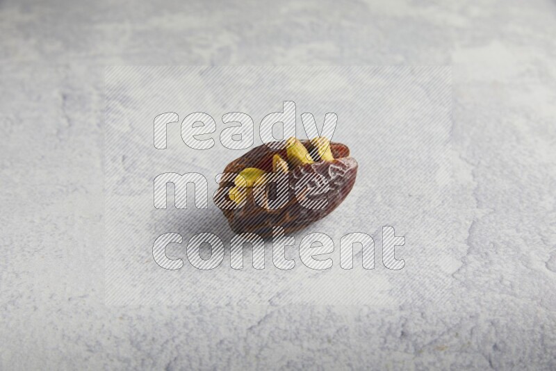 pistachio stuffed madjoul date on a light grey background