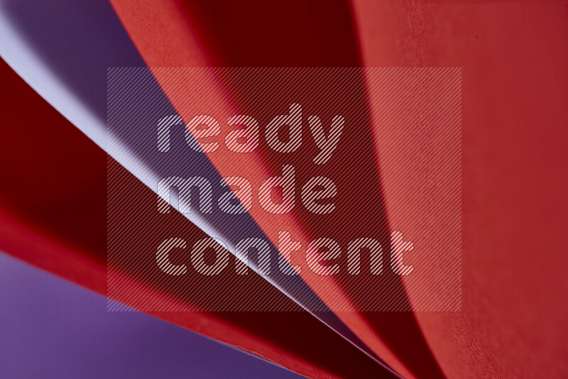 An abstract art showing purple and red paper sheets arranged in an overlapping curves