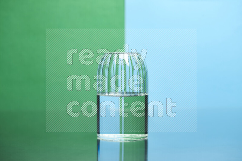 The image features a clear glassware filled with water, set against green and light blue background