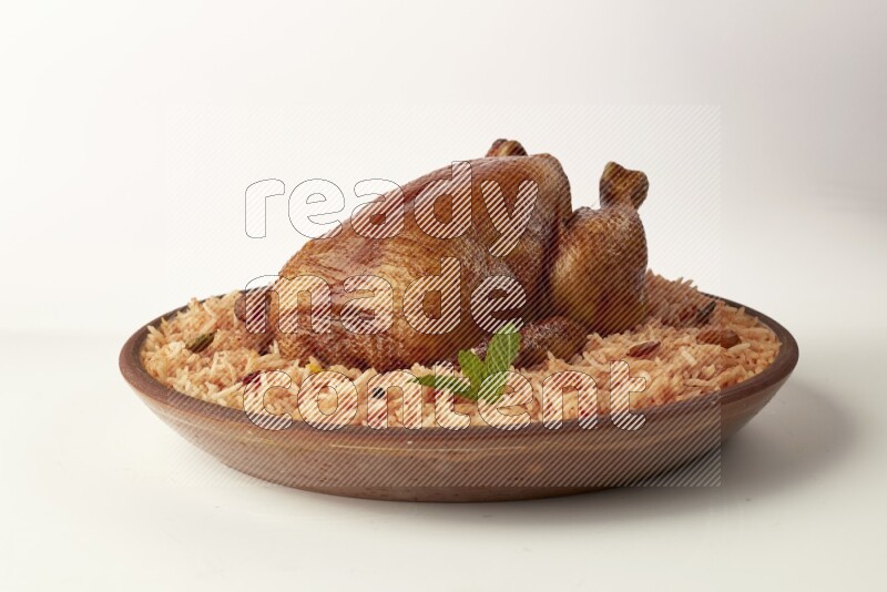 red basmati Rice with whole roasted chicken on a pottery plate direct on white background