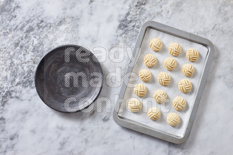 Kahk step by step with its ingredients ghee, sugar, flour, sesame, yeast, water and kahk flavor on grey marble background