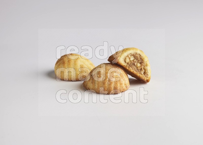 Three Pieces of Maamoul filled with walnut paste  one of them is cut direct on white background