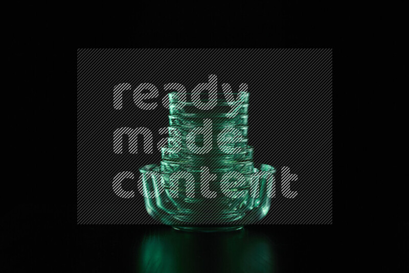 Glassware with rim light in green against black background