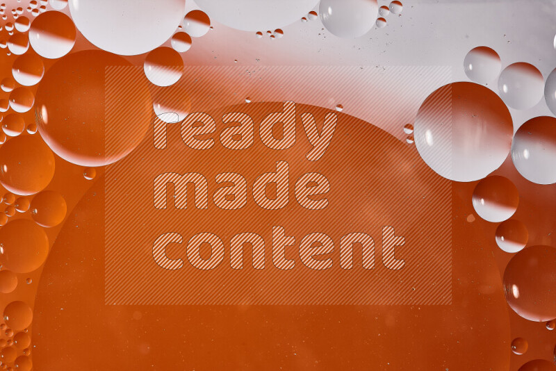 لقطات مقربة لفقاعات من الزيت على سطح الماء باللون الأبيض والبرتقالي