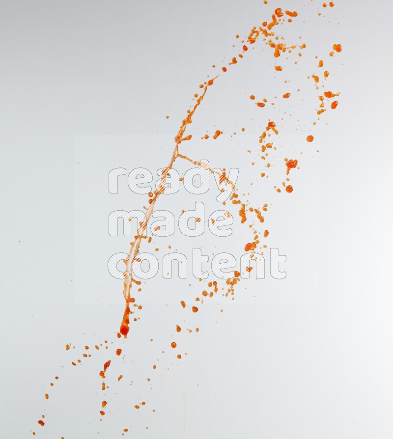 Orange liquid splash and drops on white background