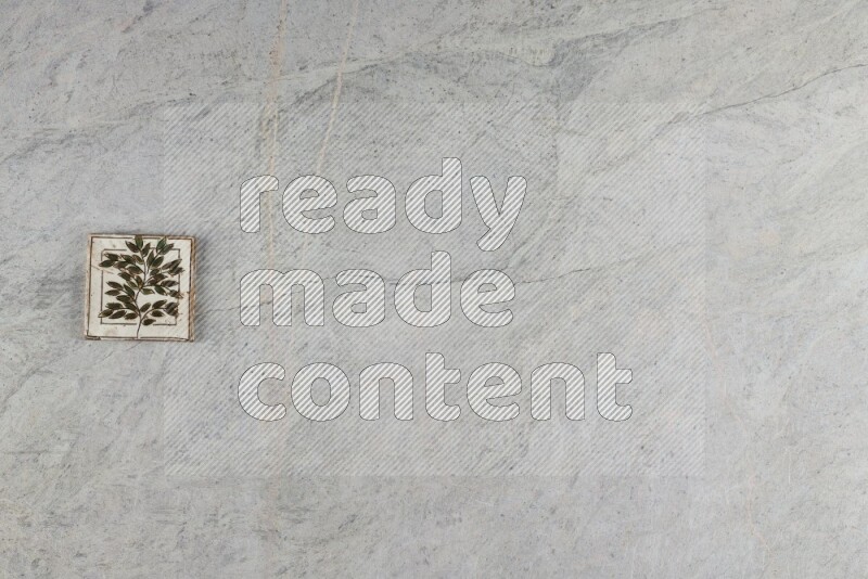 A decorative pottery coaster on grey marble background
