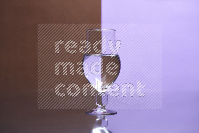 The image features a clear glassware filled with water, set against brown and light purple background