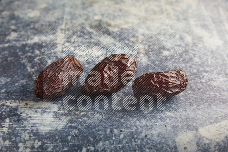 three madjoul dates on a rustic blue backround