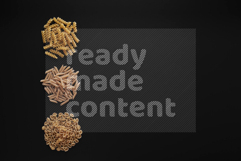 Different pasta types in 3 bunches on black background