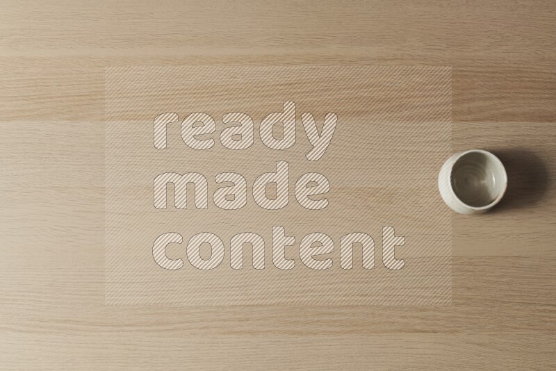 A white pottery bowl on light wooden background