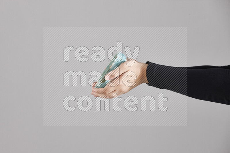 A woman in black abaya holding different pottery essentials in different positions