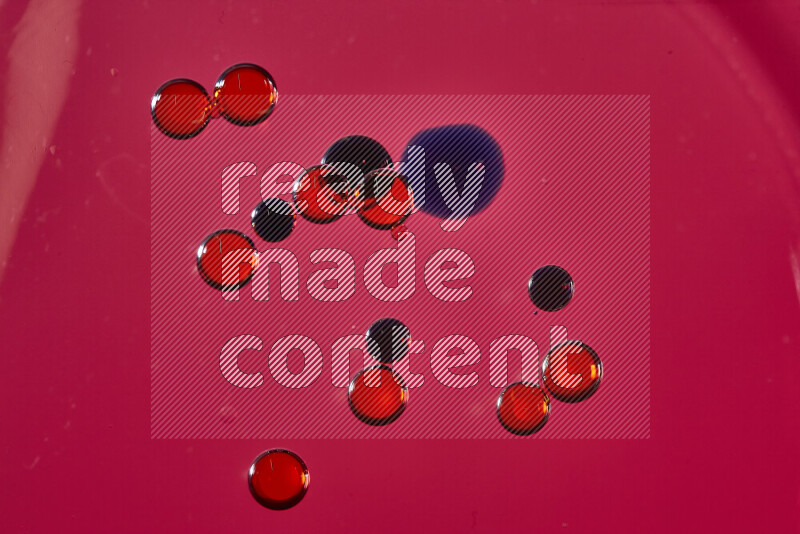Close-ups of abstract red and blue watercolor drops on oil Surface on red background