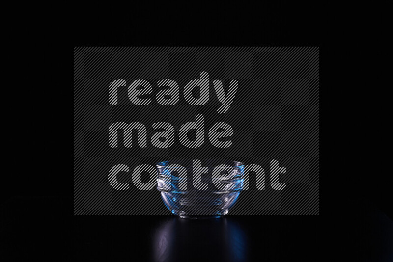 Glassware with rim light in blue and white against black background