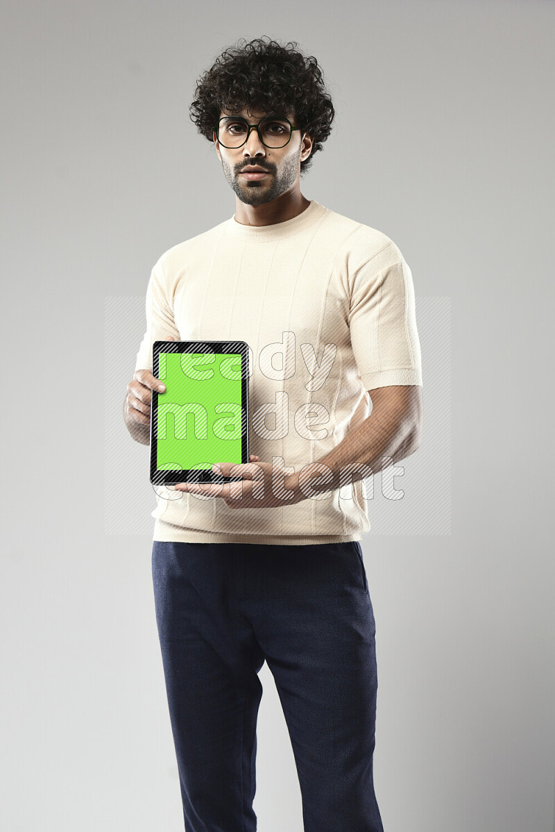 A man wearing casual standing and showing a tablet screen on white background