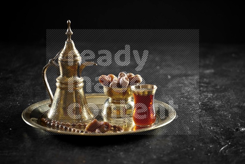 Dates with a drink on a metal tray in a dark setup