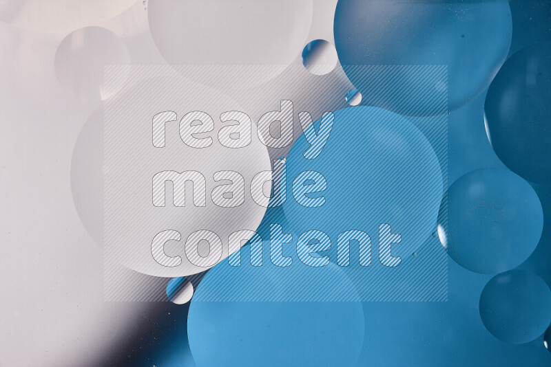 لقطات مقربة لفقاعات من الزيت على سطح الماء باللون الأبيض والأزرق