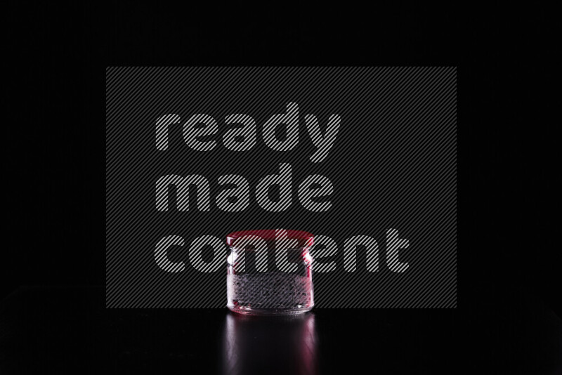 Glassware with rim light in red and white against black background