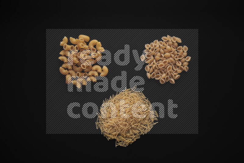Different pasta types in bunches on black background