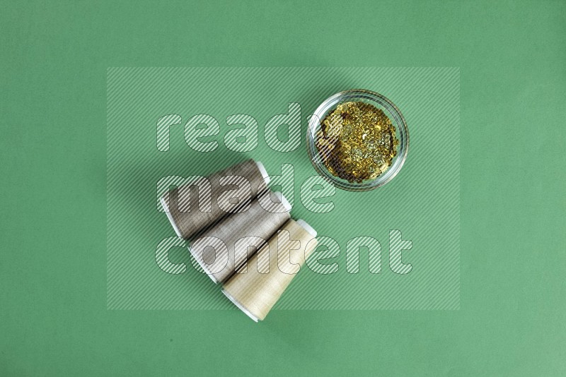 Brown sewing supplies on green background