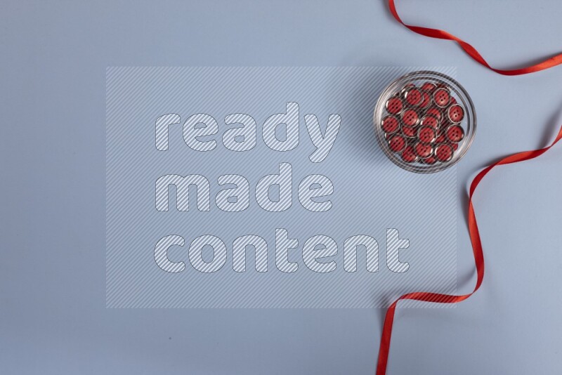 مجموعة من أدوات الخياطة والتفصيل حمراء اللون على خلفية زرقاء