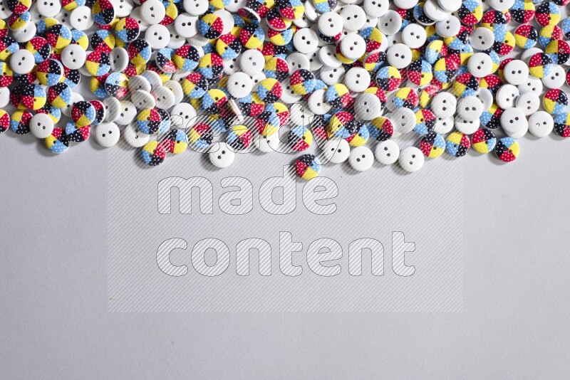 أزرار متعددة اﻷلوان موضوعة علي خلفية رمادية