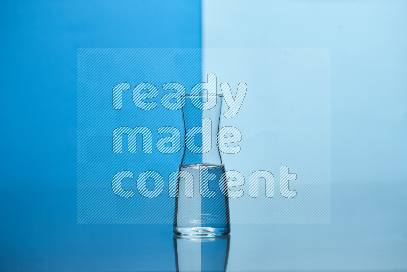 The image features a clear glassware filled with water, set against blue and light blue background