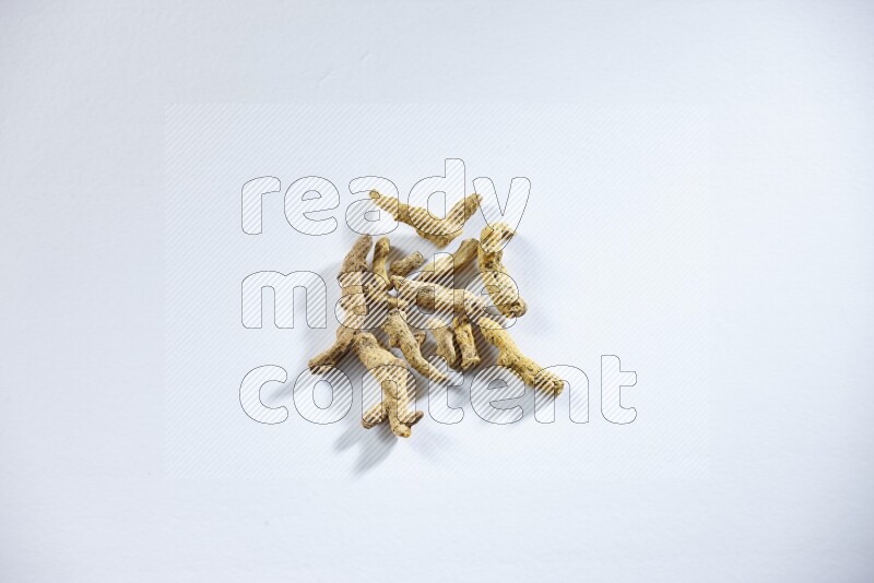 Dried turmeric whole fingers on white flooring