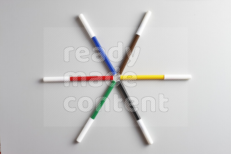 An arrangement of coloring pens in different colors on grey background