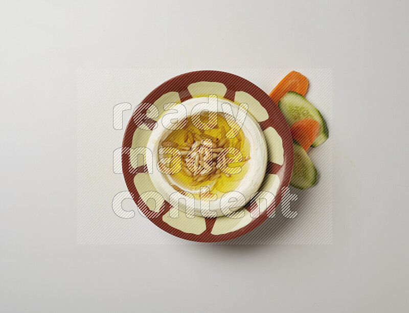Lebnah garnished with pine nuts in a traditional plate on a white background