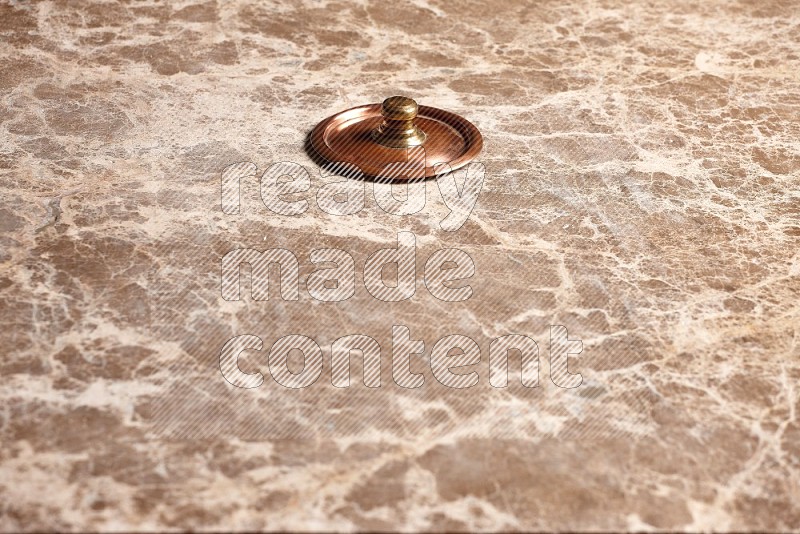Small Copper Pot's Lid on Beige Marble Flooring