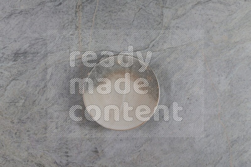 A multicolored pottery plate on grey marble background