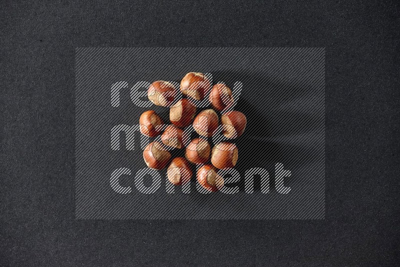 A bunch of hazelnuts on a black background in different angles