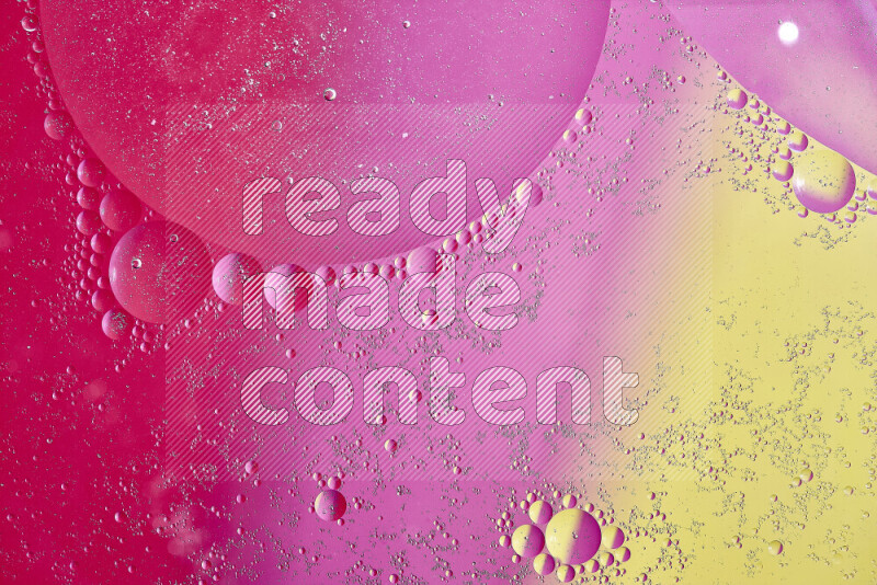 لقطات مقربة لفقاعات من الزيت على سطح الماء باللون الأصفر والوردي