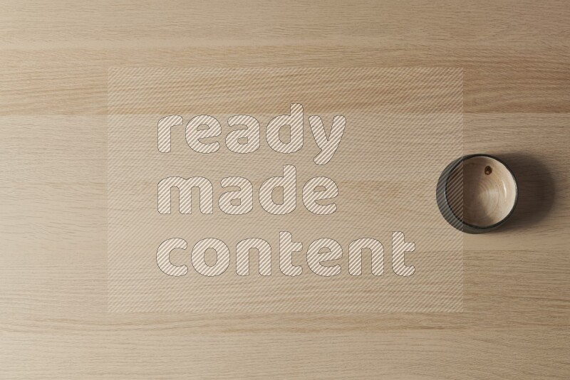A beige pottery bowl on light wooden background
