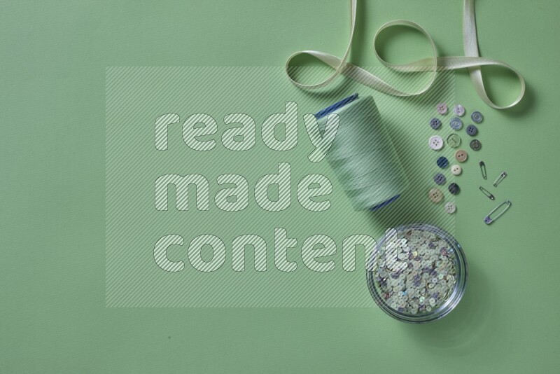 مجموعة من أدوات الخياطة والتفصيل خضراء اللون على خلفية خضراء