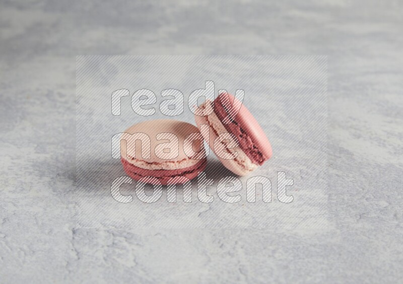 45º Shot of two Pink Litchi Raspberry macarons  on white  marble background
